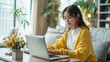 © ayame123 - リビングでパソコンを操作するアジア人の若い女性