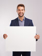 © Mariusz S/peopleimages.com - Businessman, smile and confident with poster in studio on white background for startup company as salesman. Portrait, entrepreneur and happy to advertise for sales and corporate with mockup