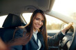 Smiling young woman taking selfie picture with camera in car.  Beautiful young woman in car, taking selfie.