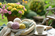 pastel colored woolen yarn balls in a white bowl standing on a garden table with booky, a cup of coffee