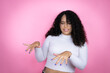 African american woman wearing casual sweater over pink background disgusted expression, displeased and fearful doing disgust face because aversion reaction.Annoying concept