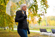 Healthy lifestyle - mid-adult woman walking in city park holding umbrella
