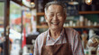 Joyful elderly man with a radiant smile, wearing an apron in a cozy café.