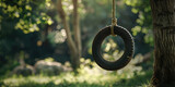 Fototapeta  - Serenity with Hanging Tire Swing, copy space. Empty tire swing hangs from a tree, evoking nostalgic summer days, childhood.