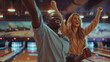 A man and woman cheer at a bowling alley