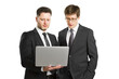 © Who is Danny - Two businessmen in suits looking at a laptop, isolated on a white background, portraying a professional work scenario