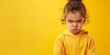Sulky girl with crossed arms on yellow