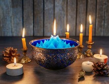 A Bowl With A Blue Fire In It Sitting On A Table Surrounded By Lit Candles And Candlesticks