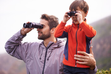 Wall Mural - Dad, kid and binoculars with smile from hiking, travel and watching in nature with adventure. Parent, youth and father with love, support and trust outdoor with family with view on trip with walking