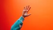 Vibrant Goodbye - A Close-Up of a Person’s Hand Waving Farewell Against a Warm, Orange Background