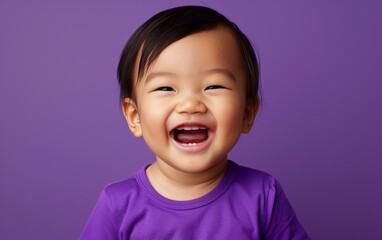 A young boy is smiling and wearing a purple shirt