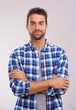 © Mariusz S/peopleimages.com - Portrait, arms crossed and man in studio for fashion isolated on a gray background. Cool person, face and confidence in casual clothes for trendy style in shirt outfit on a backdrop in Australia