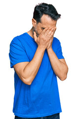 Sticker - Middle aged man with beard wearing casual blue t shirt with sad expression covering face with hands while crying. depression concept.