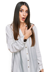 Canvas Print - Young beautiful woman wearing casual white shirt surprised pointing with finger to the side, open mouth amazed expression.