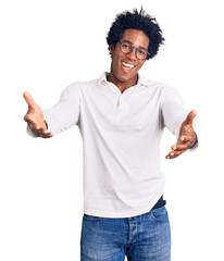 Sticker - Handsome african american man with afro hair wearing casual clothes and glasses smiling cheerful offering hands giving assistance and acceptance.