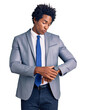 Handsome african american man with afro hair wearing business jacket checking the time on wrist watch, relaxed and confident
