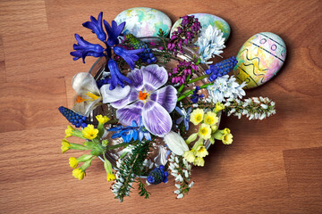 Wall Mural - a bouquet of blooming spring flowers and Easter eggs on a wooden table