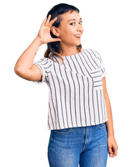 Wall Mural - Young woman wearing casual clothes smiling with hand over ear listening an hearing to rumor or gossip. deafness concept.