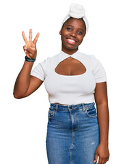 Sticker - Young african woman with turban wearing hair turban over isolated background showing and pointing up with fingers number three while smiling confident and happy.