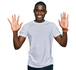 Wall Mural - Young african american man wearing casual white t shirt showing and pointing up with fingers number ten while smiling confident and happy.