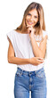 © Krakenimages.com - Beautiful caucasian woman with blonde hair wearing casual white tshirt looking confident at the camera with smile with crossed arms and hand raised on chin. thinking positive.