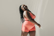 © gstockstudio - Full length of happy African plus size woman in sportswear radiating self love while standing in fitness studio