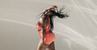 © gstockstudio - Joyful African plus size woman in sportswear dancing and radiating self-love in fitness studio