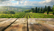 Empty wooden table for product display with blurred Italian vineyards and cypresses in the background