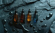 glass dropper bottles with skincare oils on a wet dark slate surface
