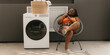 © gstockstudio - Happy plus size African woman waiting for clean clothes while sitting in chair near the washing machine in laundry