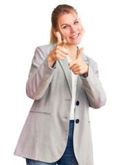 Wall Mural - Young beautiful blonde woman wearing elegant jacket pointing fingers to camera with happy and funny face. good energy and vibes.