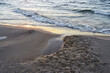 Sunset beach sand and sea wave close up.