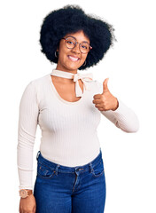 Canvas Print - Young african american girl wearing casual clothes and glasses doing happy thumbs up gesture with hand. approving expression looking at the camera showing success.