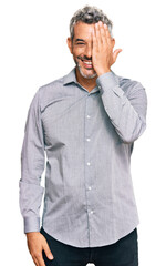 Sticker - Middle age grey-haired man wearing casual clothes covering one eye with hand, confident smile on face and surprise emotion.