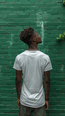 Wall Mural - Portrait of African attractive man against background of green brick wall