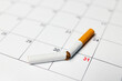 A broken cigarette lie on a calendar, symbolizing the end of smoking on Dezember 31st to stop the addiction and quit smoking while embracing a smoke free life and empowering a new beginning