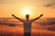 © Екатерина Переславце - man is standing in field with his arms raised, looking up at sun