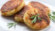 cooked fried potato cutlets with herbs on white background