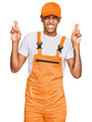 © Krakenimages.com - Young handsome african american man wearing handyman uniform gesturing finger crossed smiling with hope and eyes closed. luck and superstitious concept.