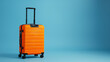 © Ummeya - Lush orange luggage ready for going travel on Pastel blue background
