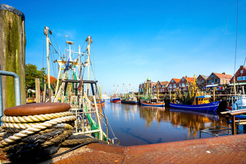 Wall Mural - Traditional harbor scene with fishing boats in Neuharlingersiel , Nordsee, Germany