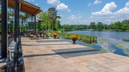 Sticker -  a patio with tables and chairs next to a body of water with flowers in a vase on the side of the walkway.