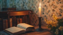 A Lit Candle On A Candlestick And An Open Book On A Wooden Table With A Patterned Wallpaper Background.