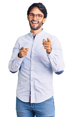 Canvas Print - Handsome hispanic man wearing business shirt and glasses pointing fingers to camera with happy and funny face. good energy and vibes.