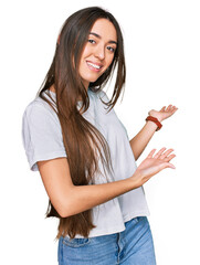 Wall Mural - Young hispanic girl wearing casual white t shirt inviting to enter smiling natural with open hand