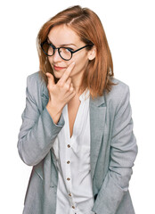 Wall Mural - Young caucasian woman wearing business style and glasses pointing to the eye watching you gesture, suspicious expression