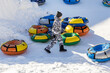Russia. Ulyanovsk. Tubing is riding on inflatable slide (cheesecakes) in the snow.
