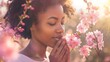Portrait of an attractive afro american woman smelling a flower in park, close up, spring backgrounds.