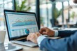 © Georgii - Business analytics expert analyzing financial data on laptop in modern office