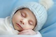 © BetterPhoto - Sleeping newborn in a blue knitted hat